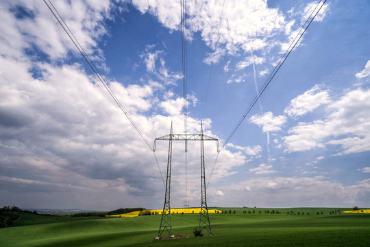 High-voltage towers and cables in agricultural fields. Rural country in South Moravia, Czech Republic.