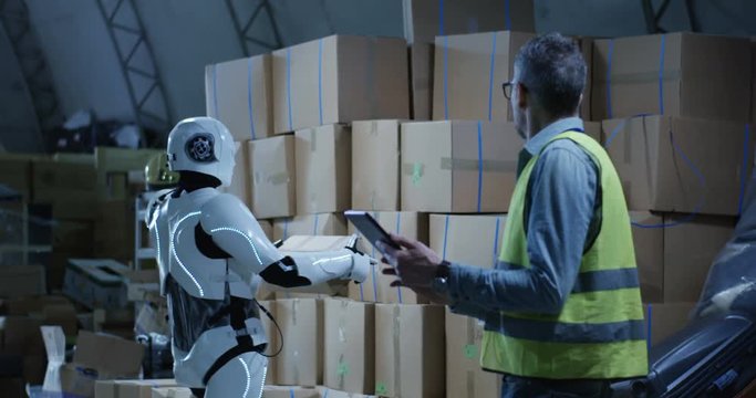 Man watching robot working in a warehouse
