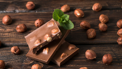 chocolate with hazelnuts on wooden background