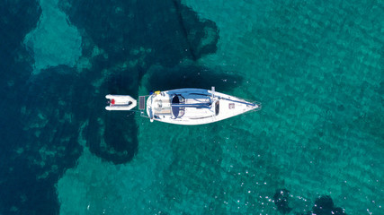Aerial drone birds eye view of sail boat cruising in the emerald Ionian sea, Greece