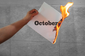 October word text on fire with burning paper