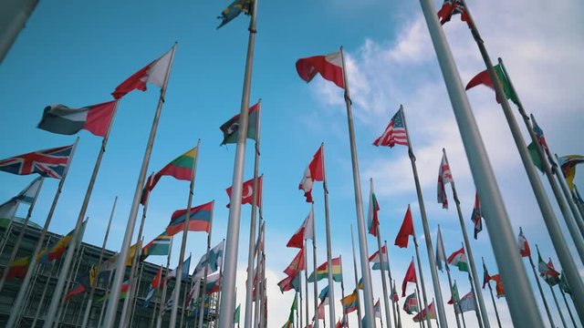 International flags of different countries waving in the wind on flagpoles
