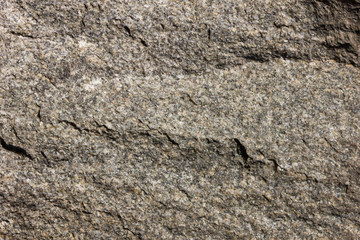 Background of granite. Texture of granite stone. Pattern of roughened surface. Texture of brown stone