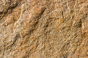 Background of granite. Texture of granite stone. Pattern of roughened surface. Texture of brown stone