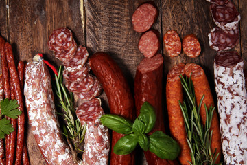 cold meat assortment with delicious salami and  fresh herbs . Variety of meat products including...