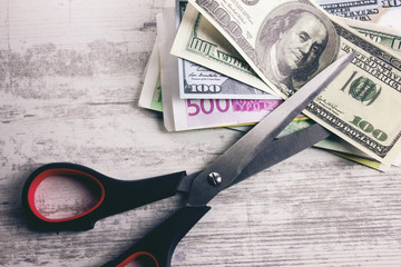 Dollar banknotes with scissors lying