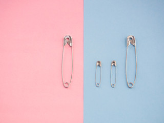 Several safety pins of various sizes in human representation. Concept of traditional family with...