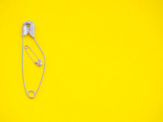 A safety pin representing a pregnant woman with a baby