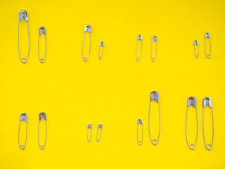 Several safety pins of different sizes. Concept of diversity and inclusion