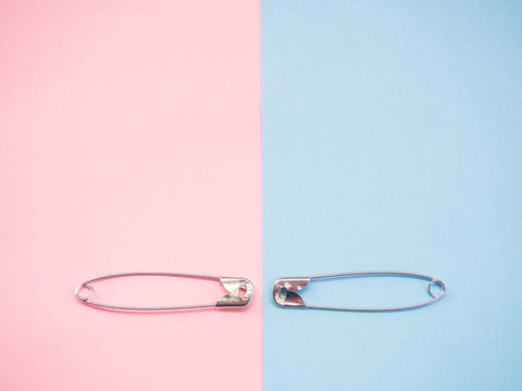 Two safety pins representing a man and a woman. Concept of machismo and feminism
