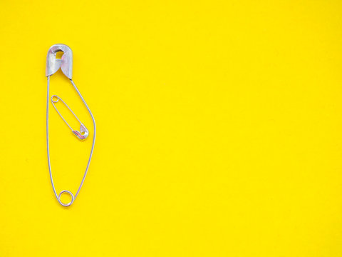 A safety pin representing a pregnant woman with a baby