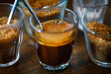 coffee in glass cup with metal spoon and sugar
