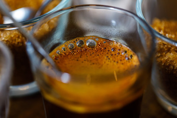 coffee in glass cup with metal spoon and sugar