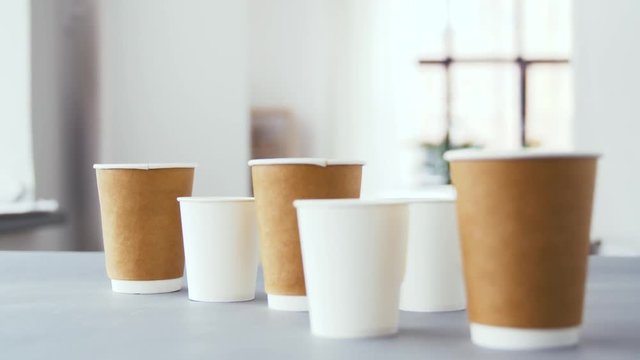 recycling and eco friendly concept - various disposable paper cups for hot drinks of different size on table