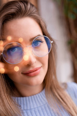 Fototapeta na wymiar Brown-eyed girl in glasses with a garland in May 2019 Moscow