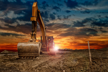Excavating machinery at the construction site, sunset in background. - 268247743