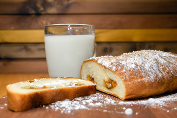 Sweet homemade bakes, bun with apple fruit filling jam and a glass of fresh milk.