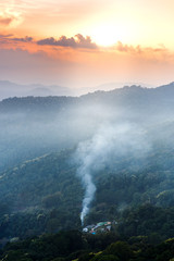 Misty mountains view landscape in rainy season in sunset