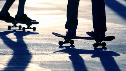 silhouette of people riding on a skateboard in the sun