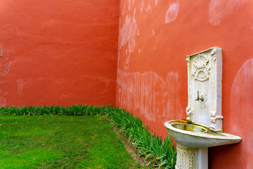 Old white basin on the red wall