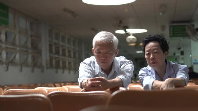 Asian senior couple talk and discuss in hospital serious health problem