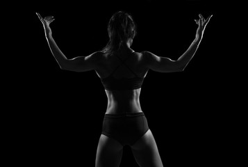Fit woman demonstrate perfect back and shoulders on black background