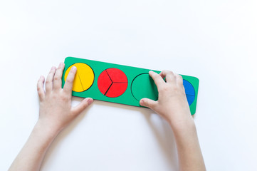 Montessori material. Children's hands. Whole and part. Fractions. The study of mathematics