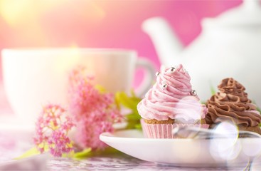 Obraz na płótnie Canvas Delicious cupcakes with cream and tea set