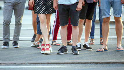 feet of people waiting for green light on the road