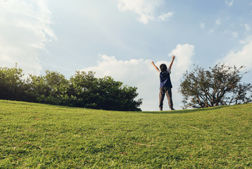 Fototapeta na wymiar happy boy raising arms in summer