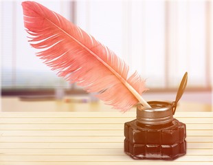 Feather pen into the inkwell isolated