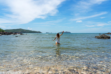Asian woman walking in clear sea on Koh Kham island