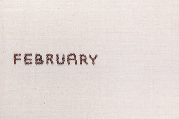 The word February written with coffee beans shot from above, aligned to the left.