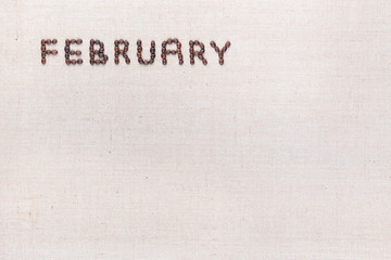The word February written with coffee beans shot from above, aligned at the top left.