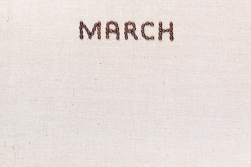 The word March written with coffee beans shot from above, aligned at the top.