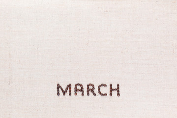 The word March written with coffee beans shot from above, aligned at the bottom.