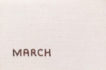 The word March written with coffee beans shot from above, aligned at the bottom left.