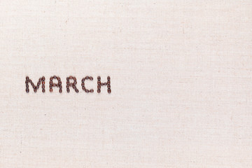The word March written with coffee beans shot from above, aligned to the left.