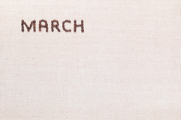 The word March written with coffee beans shot from above, aligned at the top left.