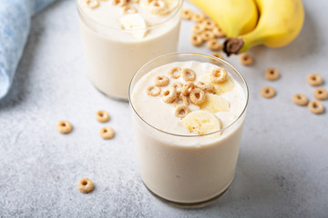 Healthy banana smoothie in glasses topped with cereal