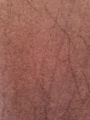 Light brown fabric with streaks of darker color creating a design