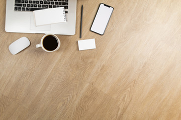 Stylish office table desk. Workspace with laptop, mouse, notepad, pencil, mobile phone and coffee on white oak wooden blackground. Flat lay, top view