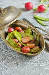 Fried young peas and radish pods. In the style of Provence. light background. Soft focus