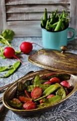 Fried young peas and radish pods. In the style of Provence. light background. Soft focus