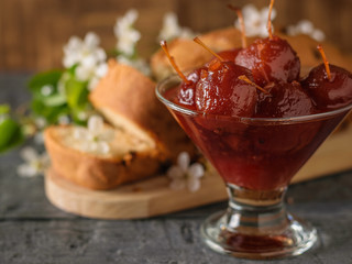 Apple jam in a glass bowl on the background of fresh cake.