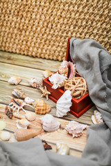 Close up Ancient casket for jewelry with collection of different seashells on wooden table.