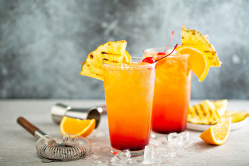 Tequila sunrise cocktail with grilled pineapple and orange - obrazy, fototapety, plakaty