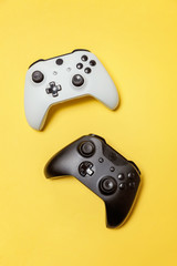 White and black two joystick gamepad, game console on yellow colourful trendy modern fashion pin-up...