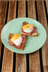 Crepes with poached egg, grilled bacon, cheese and herbs