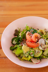 Vegetable salad with tomatoes, cucumbers and greens, flavoured with sesame and olive oil for a perfect vegan dinner